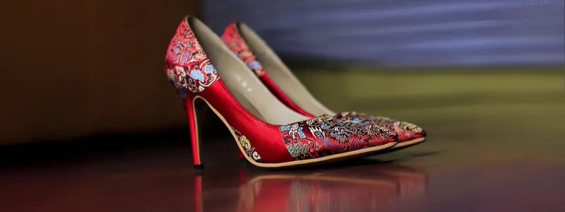 Custom-Made High Heels: Final Perfection 2 A pair of red stilettos with narrow heels and embroidered floral embellishments.