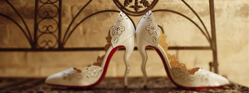 An extra expensive embellished pair of high heels on an ornate period chair.