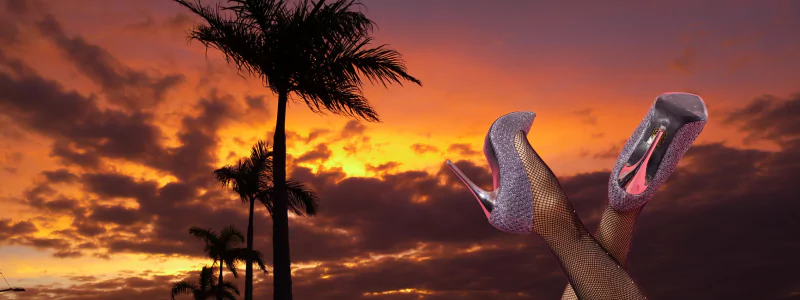 GTA 6 Heels: Genius Game-Changer? 4 Shiny stiletto heels in a purple-pink shade with a diamond-like texture, radiating a Vice City vibe, set against a backdrop of palm trees at sunset like a GTA 6 Heels.